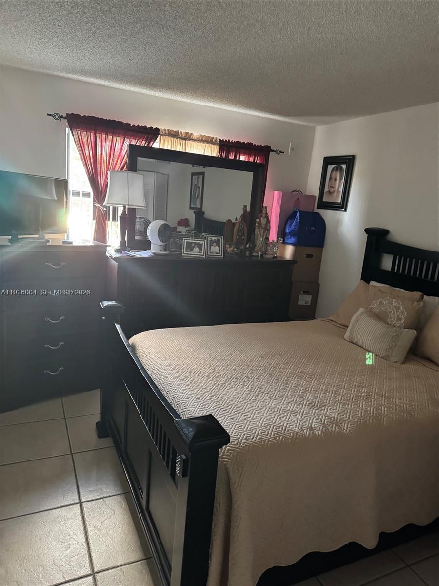 7155 Northwest 179th Street, Unit 112 Hialeah, FL 33015 - Photo 4 of 7 a bedroom with a bed and window