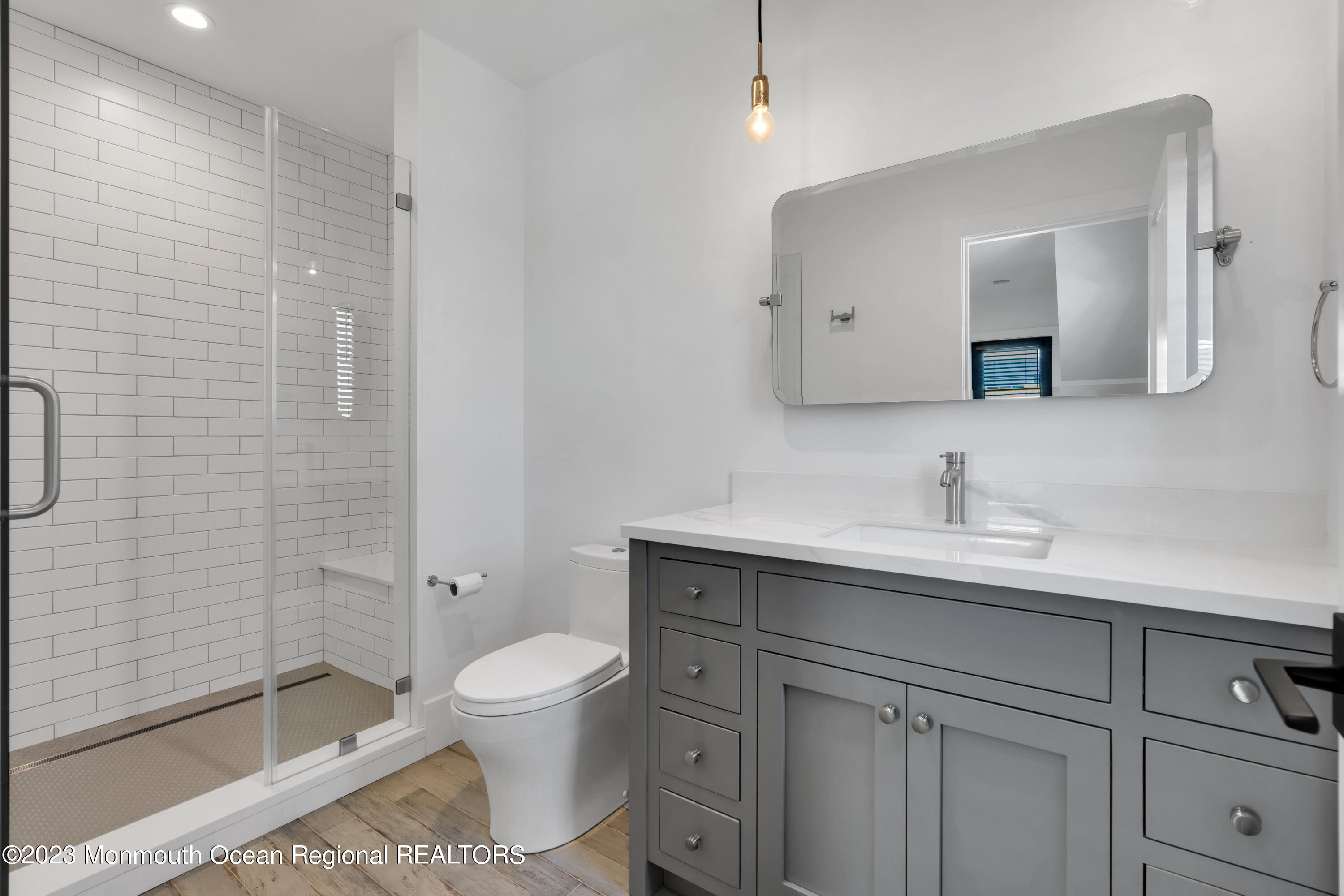 1125 North Ocean Avenue Mantoloking, NJ 08738 - Photo 45 of 69 a bathroom with a toilet a sink a glass door a shower and mirror