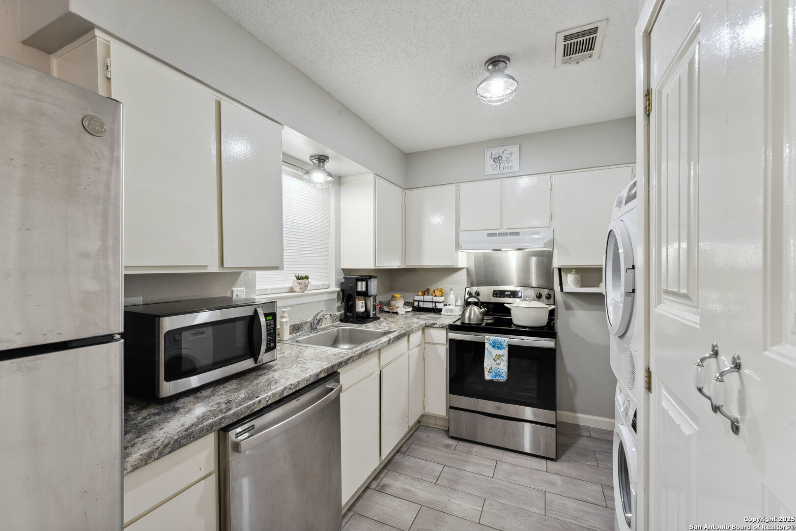 923 Vance Jackson Road, Unit 1104 San Antonio, TX 78201 - Photo 8 of 18 a kitchen with stainless steel appliances granite countertop a stove a sink and a refrigerator