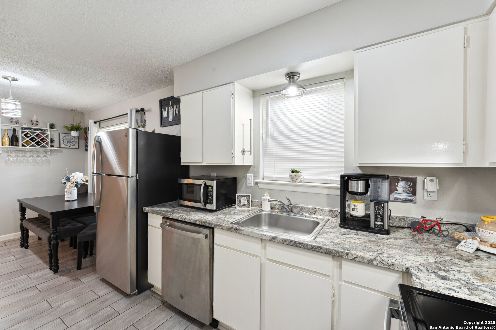 923 Vance Jackson Road, Unit 1104 San Antonio, TX 78201 - Photo 10 of 18 a kitchen with a sink dishwasher a refrigerator and a stove with wooden floor