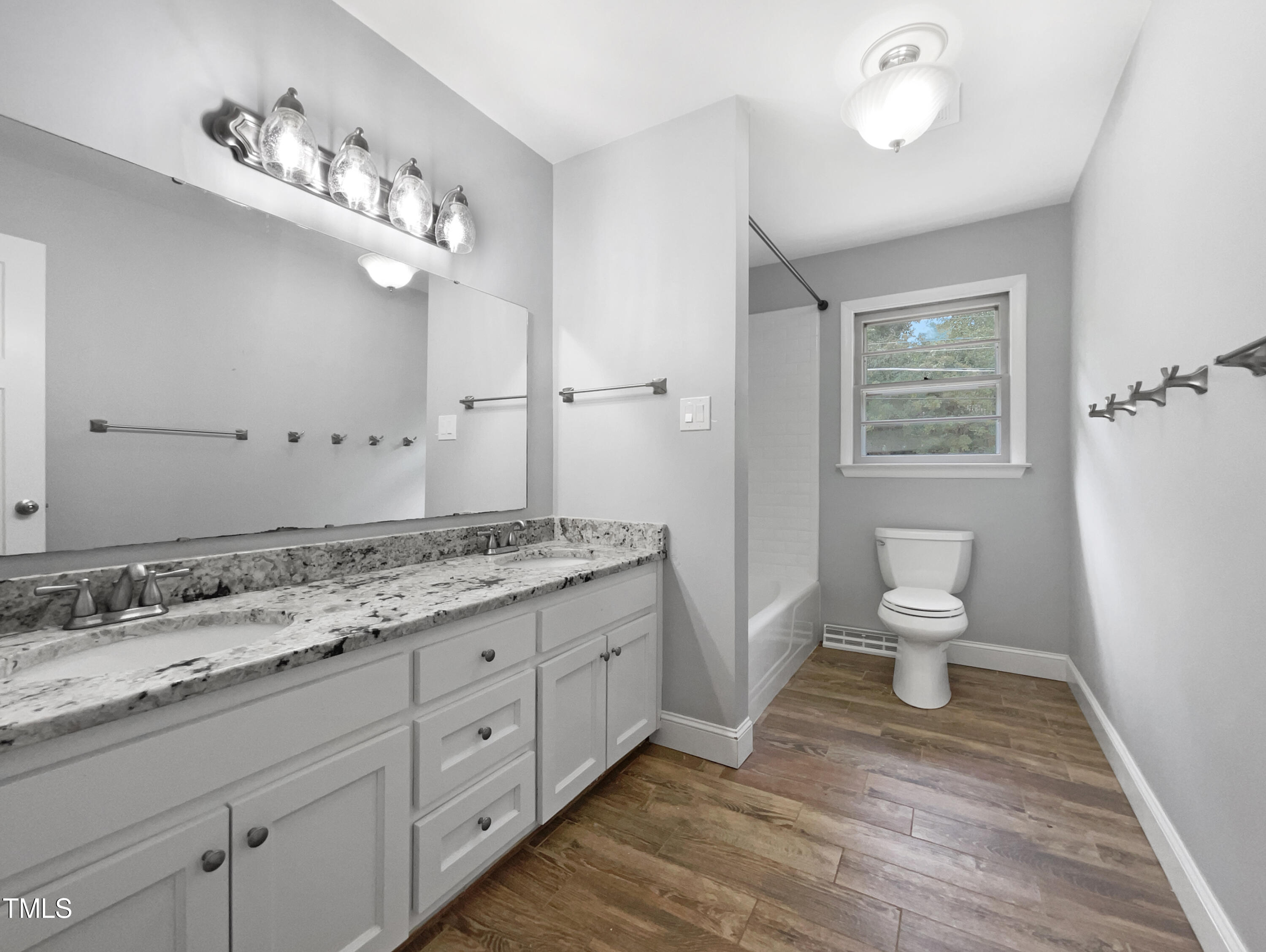 6310 Brandywine Road Raleigh, NC 27607 - Photo 7 of 22 a spacious bathroom with a granite countertop sink a toilet and a mirror