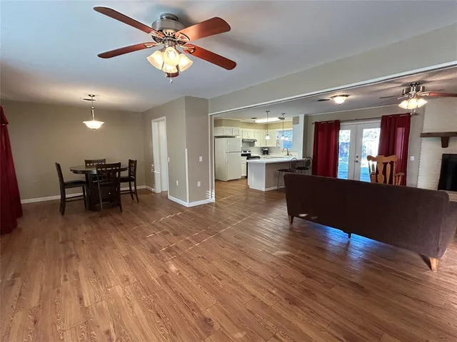a view of a dining room with furniture a chandelier and wooden floor