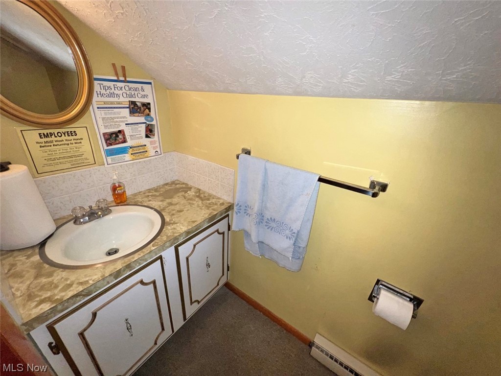 918 Amherst Road Northeast Massillon, OH 44646 - Photo 27 of 31 Bathroom with backsplash, a textured ceiling, and large vanity