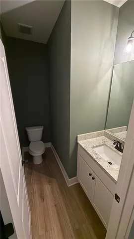 a bathroom with a granite countertop sink toilet and a mirror