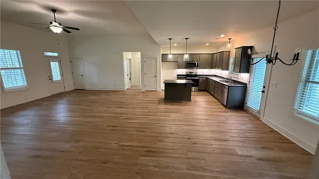 a kitchen with stainless steel appliances kitchen island granite countertop a stove refrigerator and a sink