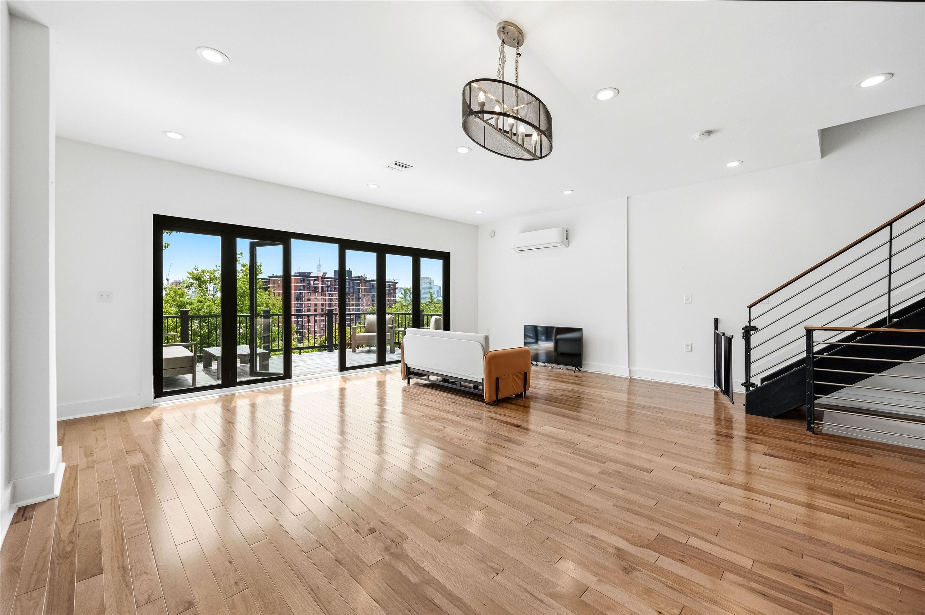 107 Mountain Road Jersey City, NJ 07307 - Photo 5 of 41 a view of an empty room with wooden floor and windows