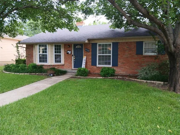 a front view of a house with a garden and plants