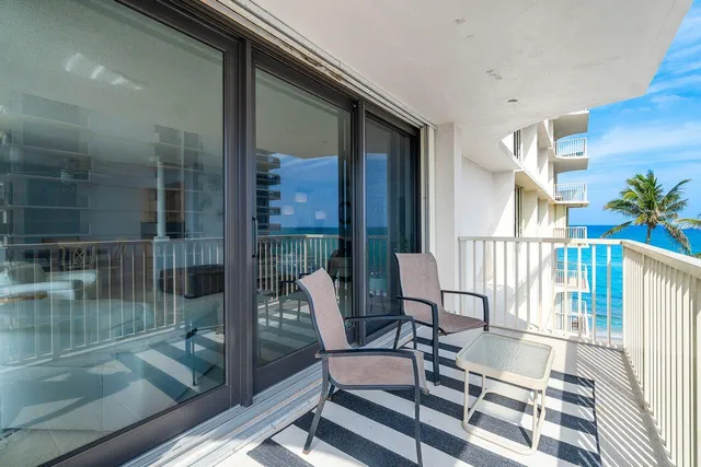 a balcony with chairs and with potted plants