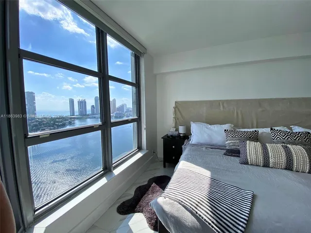 a bedroom with a large bed and a large window