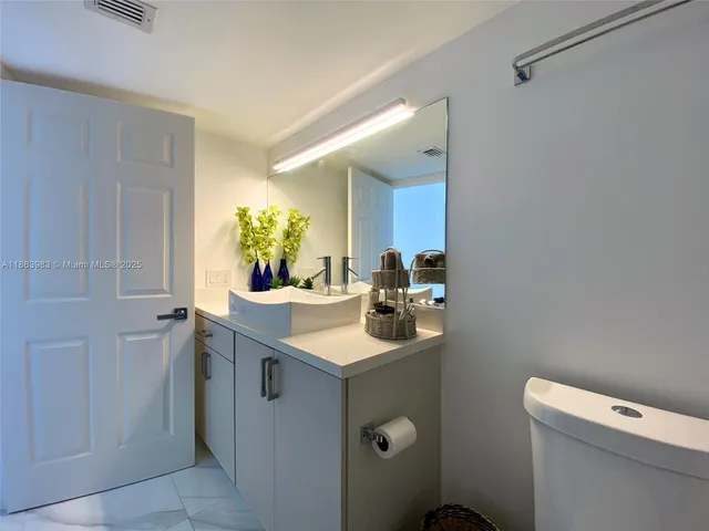 a bathroom with a sink toilet and mirror