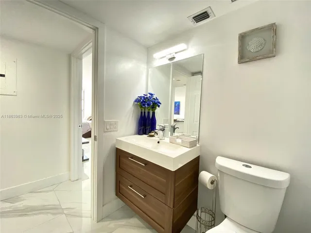 a bathroom with a sink mirror vanity and toilet