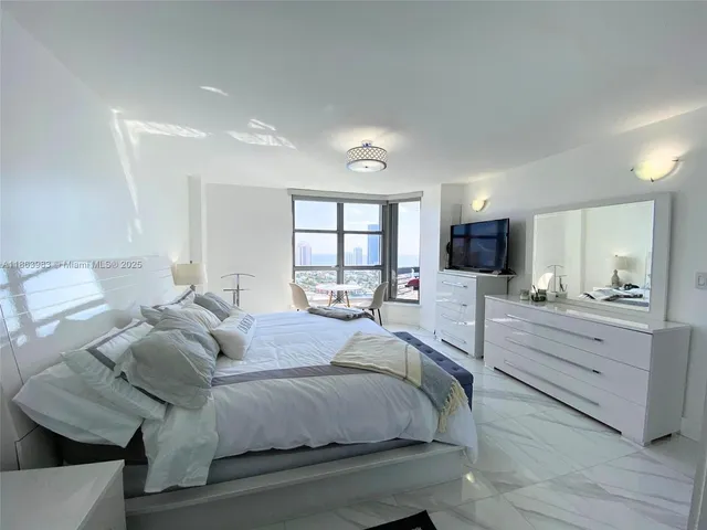 a large bedroom with a bed and a large window