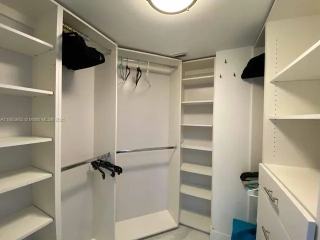 a view of walk in closet with empty racks