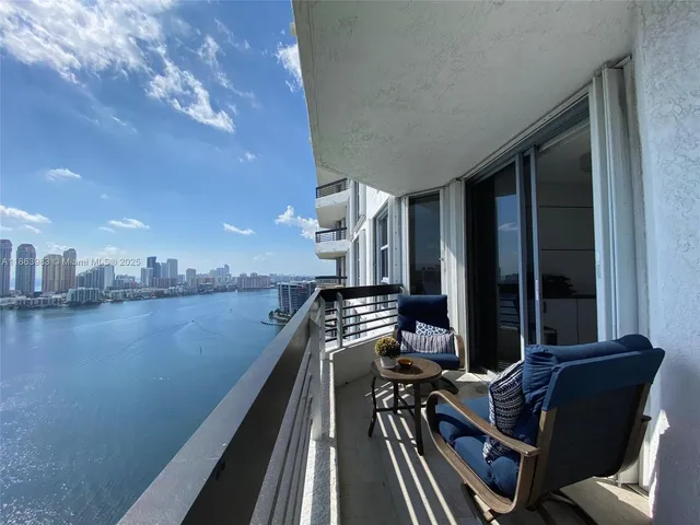 a view of a balcony with chairs and wooden floor