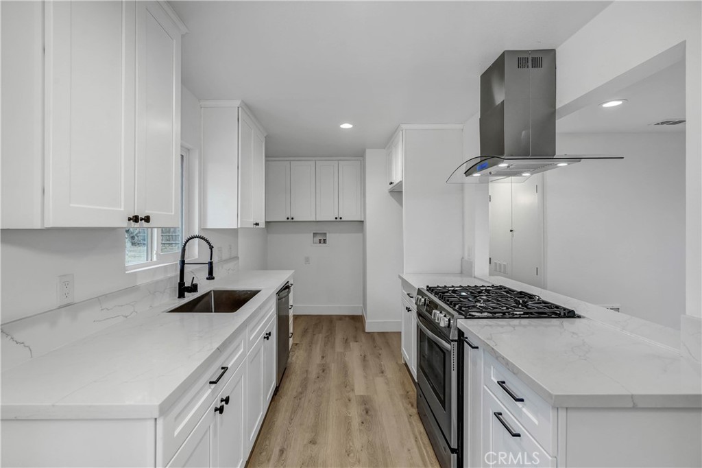 a kitchen with granite countertop a sink stove and cabinets