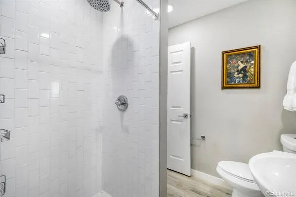 a view of a hallway with bathroom and wooden floor