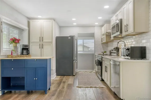 a kitchen with stainless steel appliances granite countertop a sink stove and refrigerator
