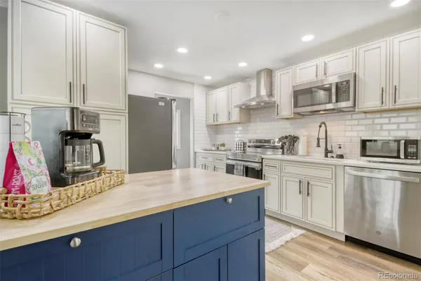 a kitchen with stainless steel appliances granite countertop a refrigerator and a sink