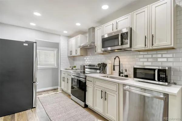 a kitchen with stainless steel appliances granite countertop a sink a stove and cabinets