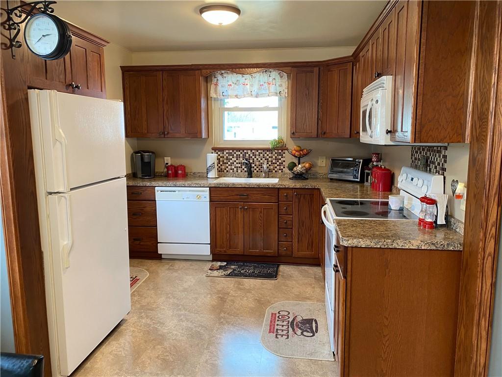 3545 Ellwood Road New Castle, PA 16101 - Photo 5 of 25 a kitchen with granite countertop a refrigerator a stove a sink and dishwasher with wooden floor