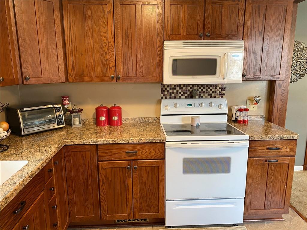 3545 Ellwood Road New Castle, PA 16101 - Photo 6 of 25 a kitchen with granite countertop wood cabinets and white appliances