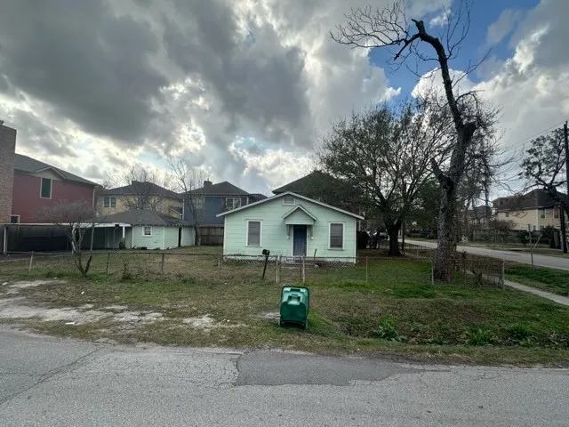 a view of a house with a yard and large tree