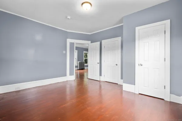 a view of an empty room with wooden floor