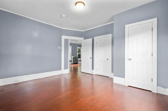 a view of an empty room with wooden floor
