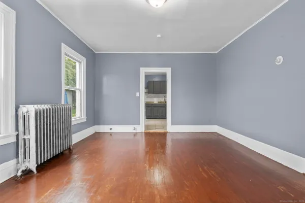 an empty room with wooden floor and windows