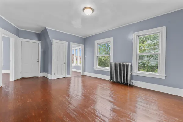 an empty room with wooden floor and windows