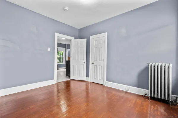 a view of an empty room with wooden floor