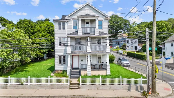 a view of a brick house with a yard and plants