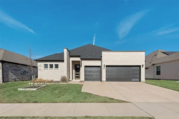 a front view of a house with a garden and yard
