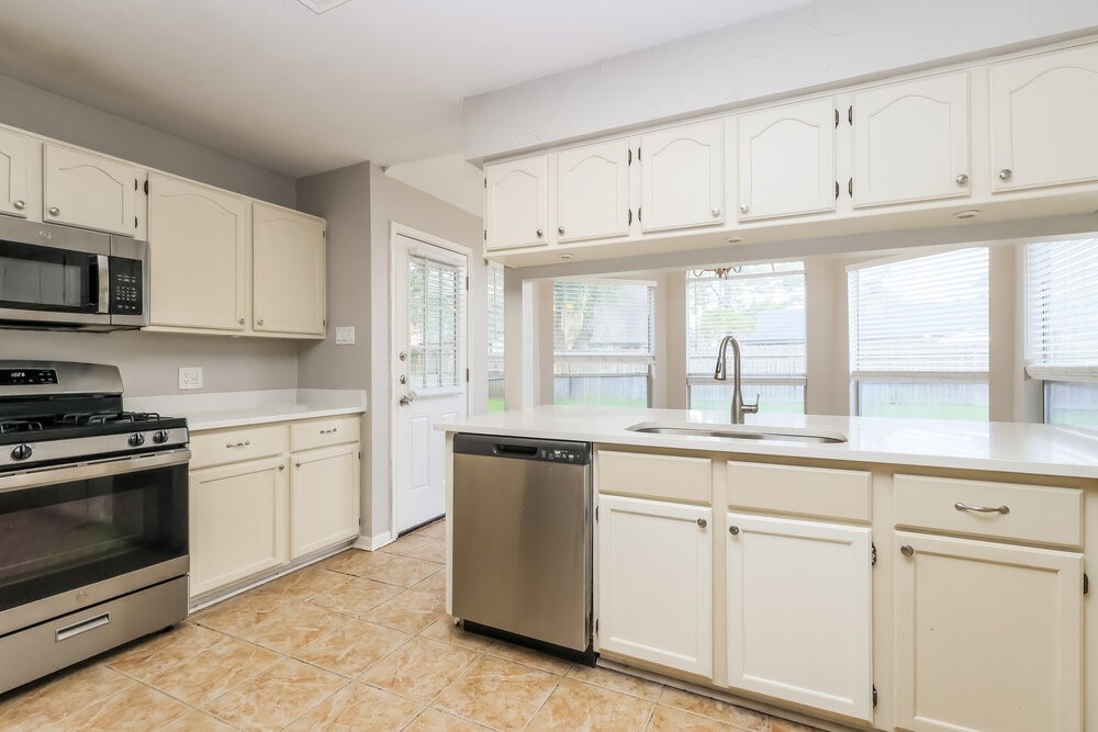 2711 Knollbrook Lane Spring, TX 77373 - Photo 8 of 17 a kitchen with granite countertop white cabinets white stainless steel appliances with a sink and dishwasher