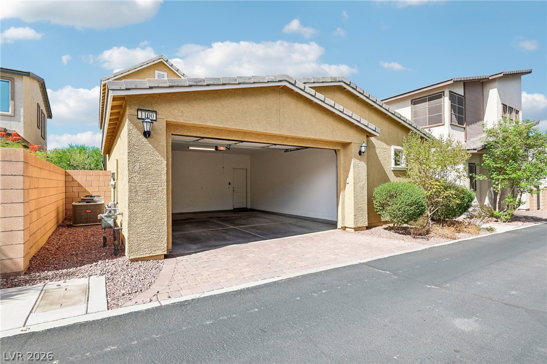 1100 East Sunset Road Henderson, NV 89011 - Photo 46 of 63 A spacious attached garage provides convenient vehicle storage alongside a paved driveway.