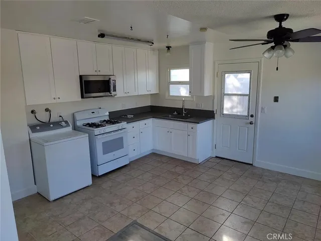 a kitchen with white cabinets a sink and appliances