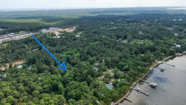 an aerial view of a house with a yard and lake view