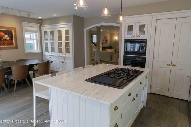 a kitchen with a stove a refrigerator and a dining table