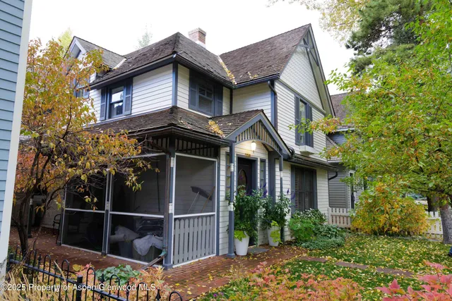 a view of a house with brick walls and flower plants