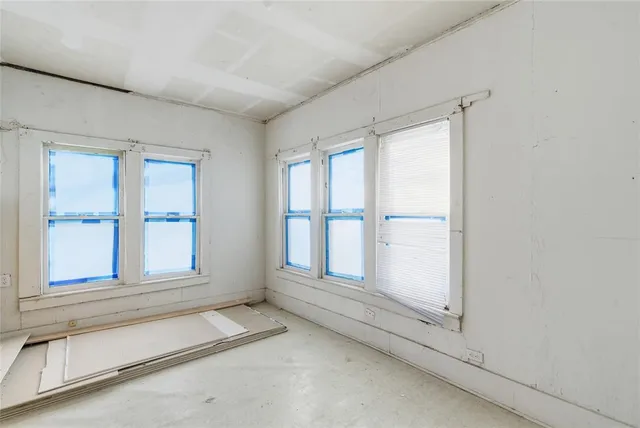 an empty room with windows and closet