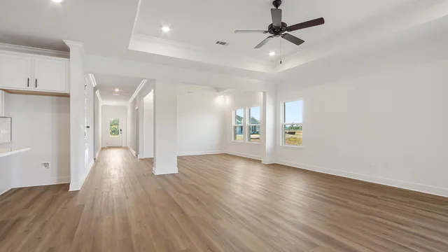 a view of kitchen with kitchen island stainless steel appliances refrigerator stove and wooden floor
