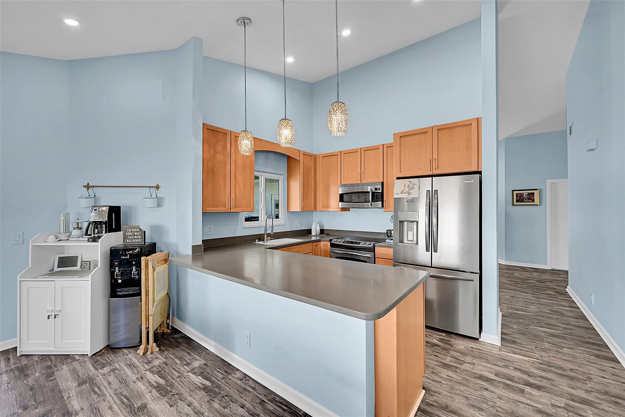 22533 Swordfish Drive Boca Raton, FL 33428 - Photo 15 of 49 a kitchen with stainless steel appliances wooden floor sink and wooden cabinets