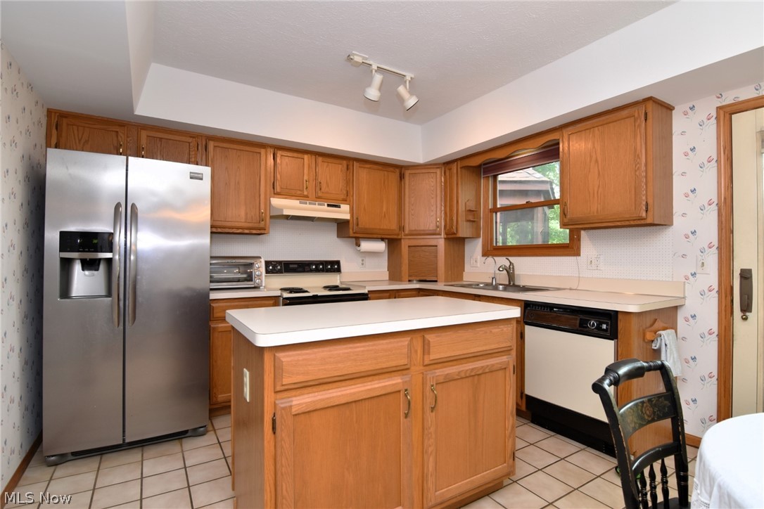 7655 Bellflower Road Mentor, OH 44060 - Photo 8 of 28 Kitchen with light tile patterned flooring, white appliances, a center island, track lighting, and sink