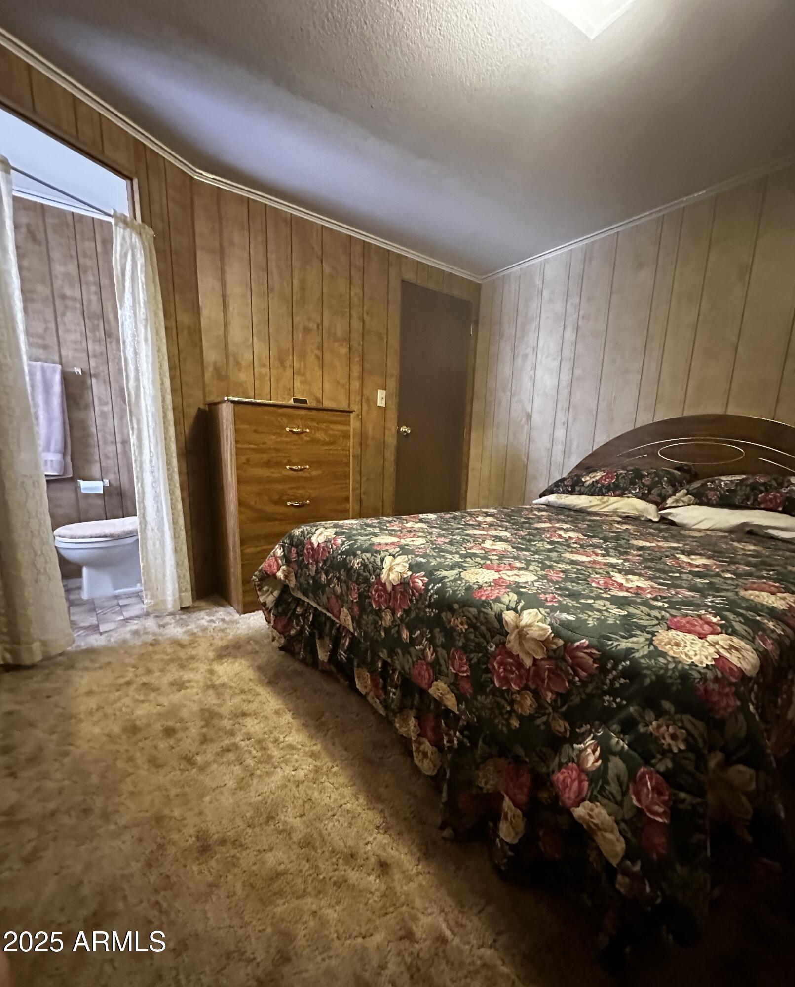 2605 South Tomahawk Road, Unit 8 Apache Junction, AZ 85119 - Photo 12 of 21 a bed sitting in a spacious bedroom next to a window