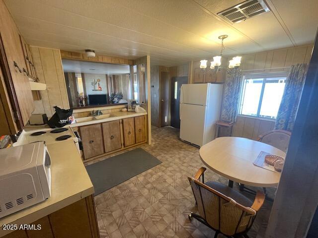 2605 South Tomahawk Road, Unit 8 Apache Junction, AZ 85119 - Photo 3 of 21 a large kitchen with a stove a sink dishwasher a microwave oven and a dining table with wooden floor