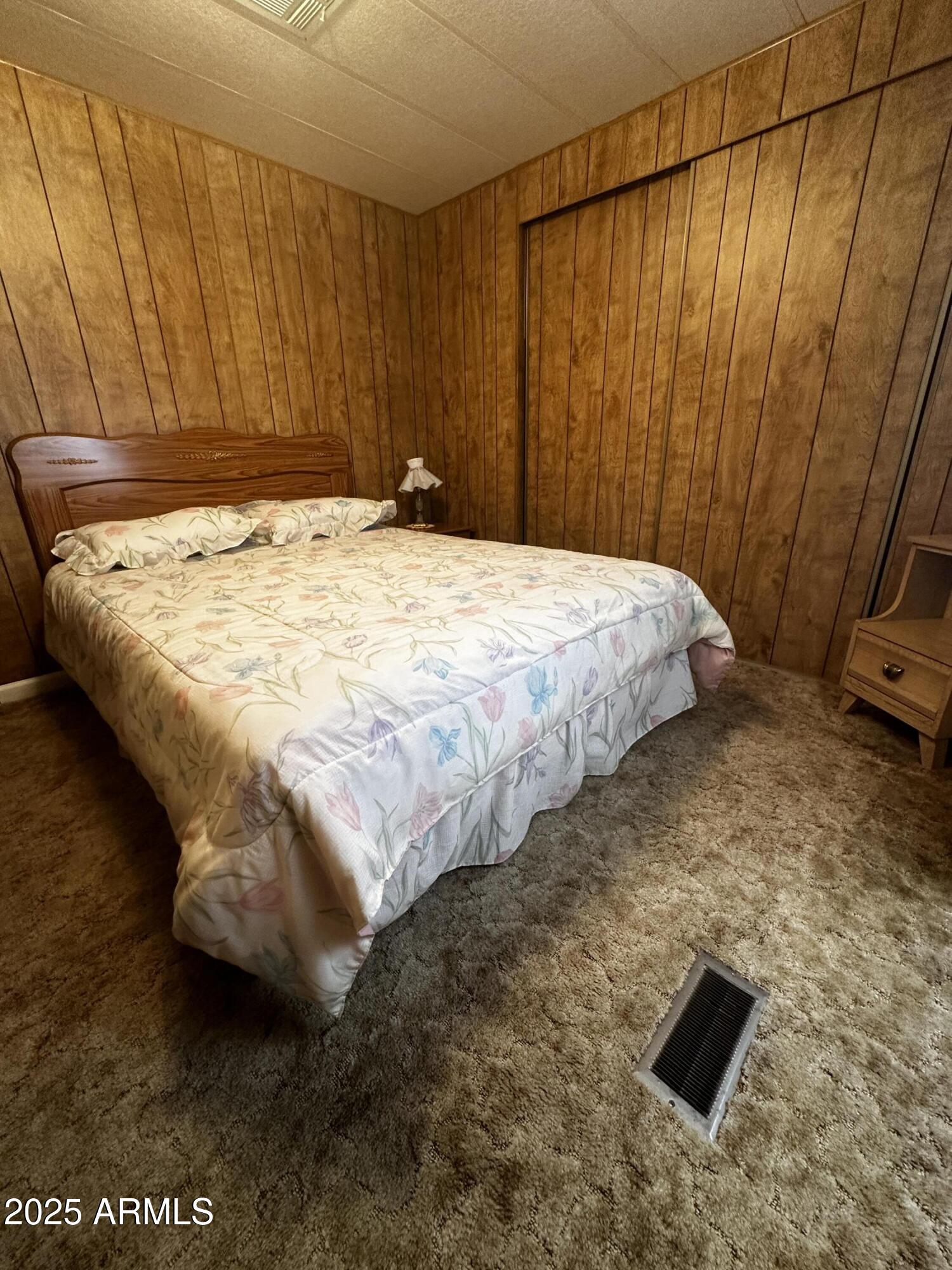 2605 South Tomahawk Road, Unit 8 Apache Junction, AZ 85119 - Photo 10 of 21 a bed sitting in a bedroom next to a wooden cabinet
