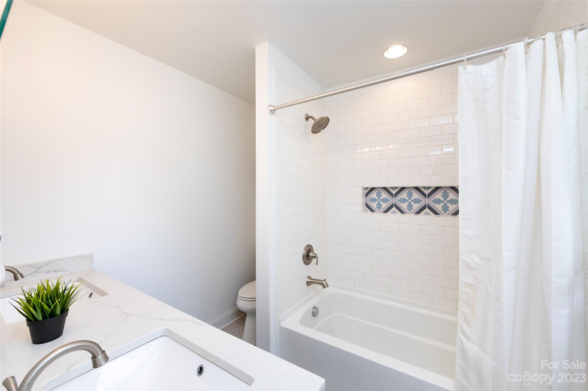 513 Sandridge Road Charlotte, NC 28210 - Photo 17 of 32 a bathroom with a bathtub shower and a sink