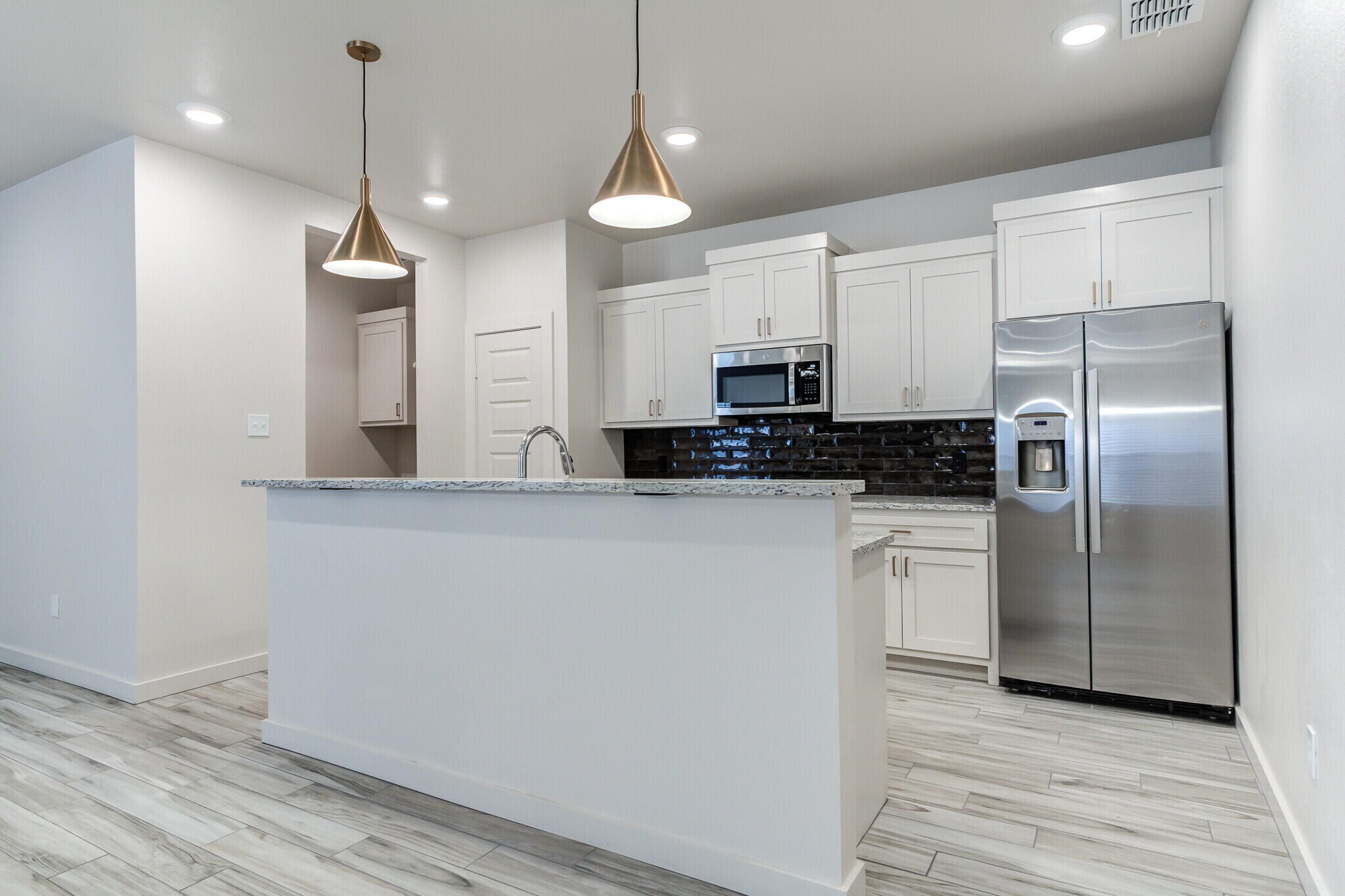 7048 41st Street Lubbock, TX 79407 - Photo 12 of 34 a kitchen with stainless steel appliances a refrigerator sink and microwave