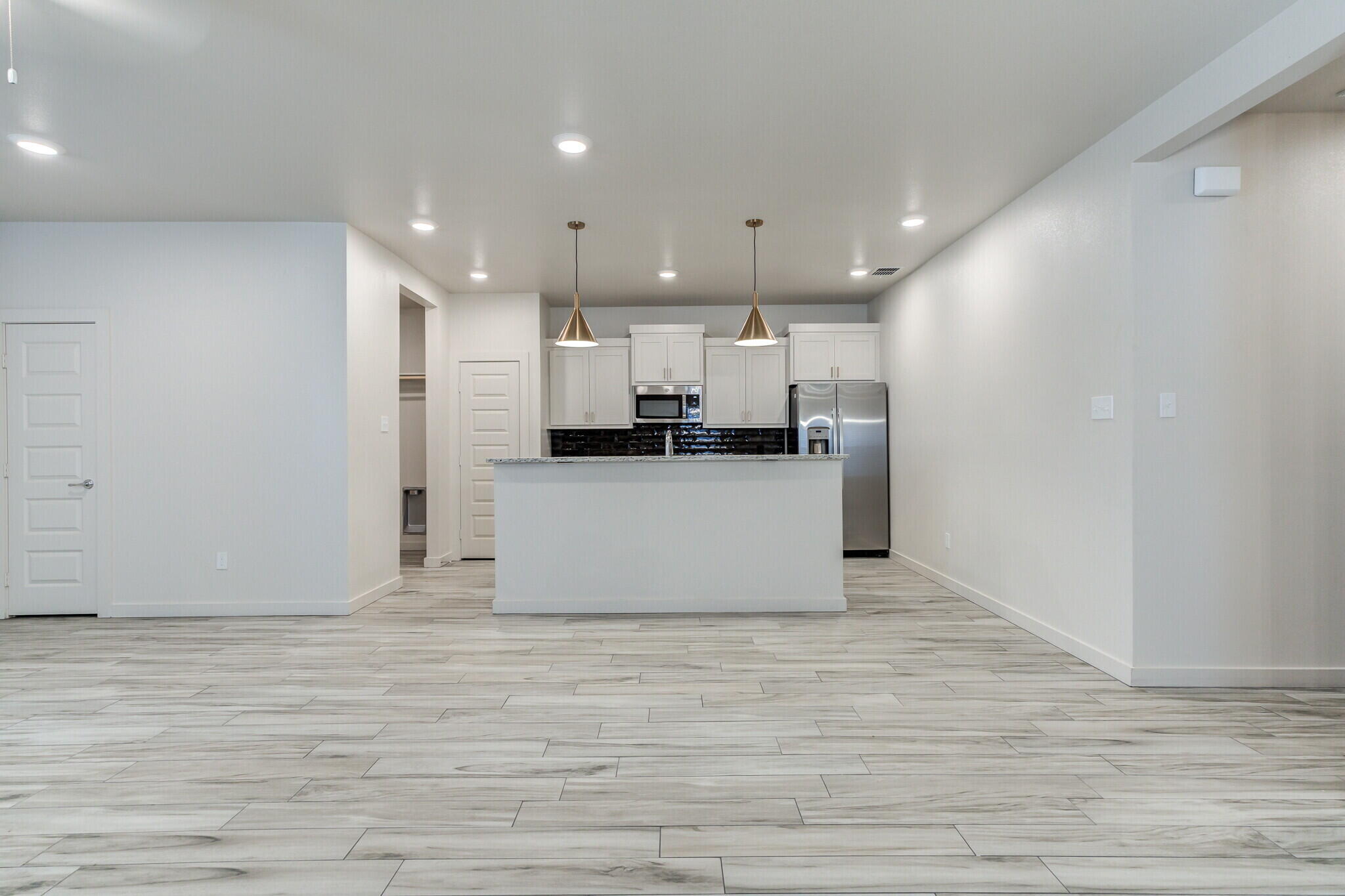 7048 41st Street Lubbock, TX 79407 - Photo 10 of 34 a view of a kitchen with kitchen island wooden floor center island and stainless steel appliances