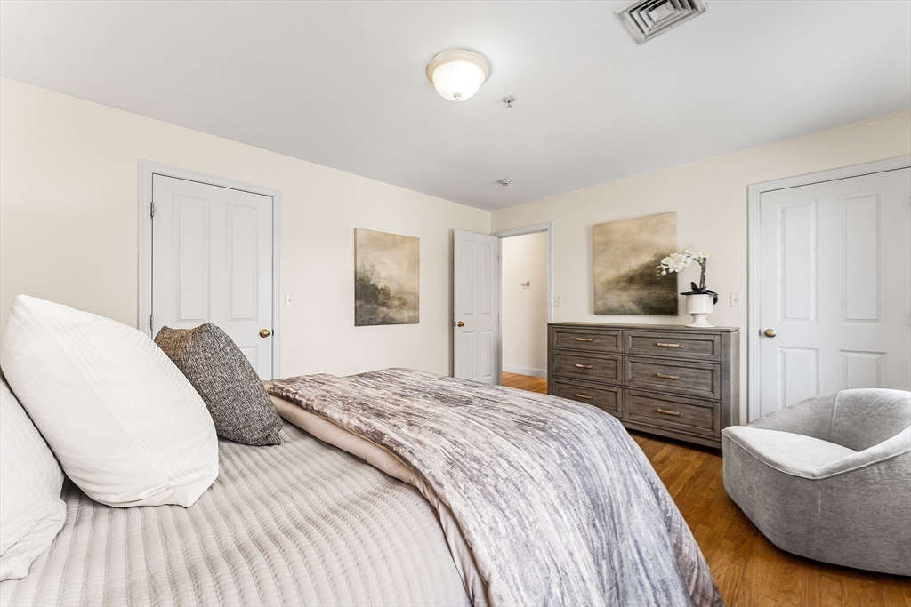 30 Russell Street, Unit 5 Waltham, MA 02453 - Photo 16 of 26 a bedroom with a bed and wooden floor